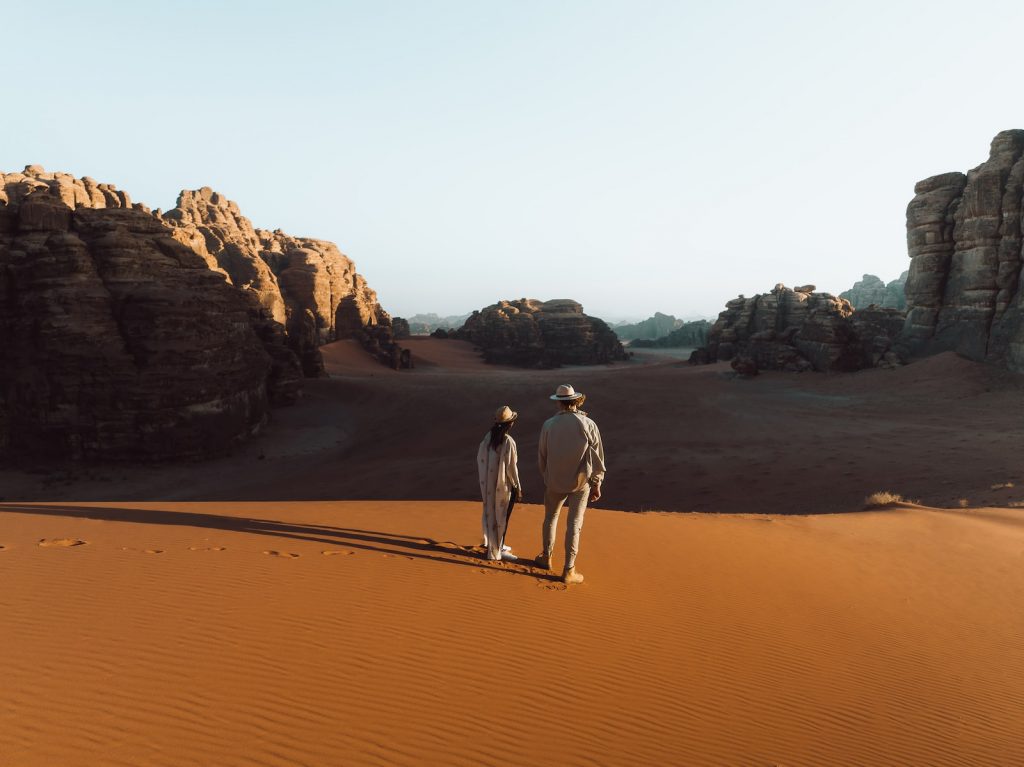 A man and a woman walking in the desert