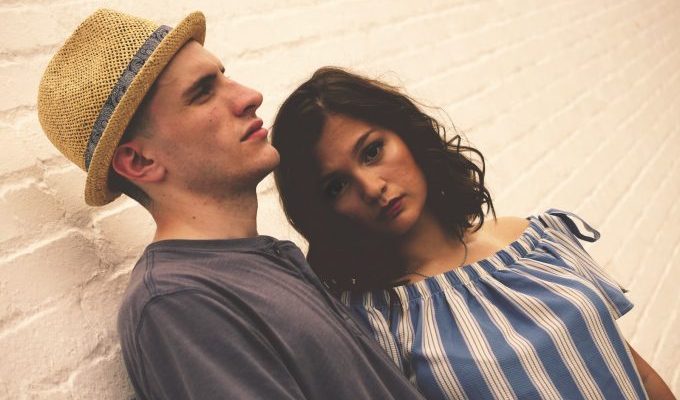 Man and woman standing near brick wall